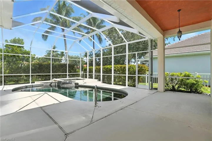 View of swimming pool with a patio area, a pool with connected hot tub, and a lanai - Virtually Edited Image