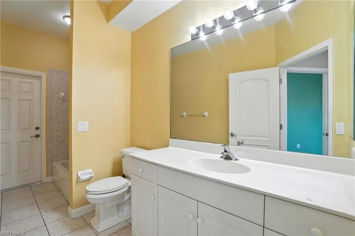 Bathroom featuring vanity, tile patterned floors, and shower / tub combination - Virtually Edited Image