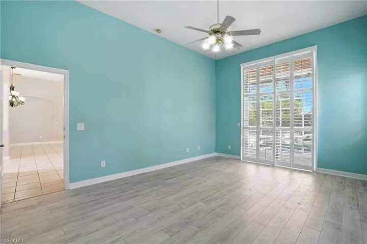 Primary Bedroom featuring a chandelier, a ceiling fan, and wood finished floors - Virtually Edited Image