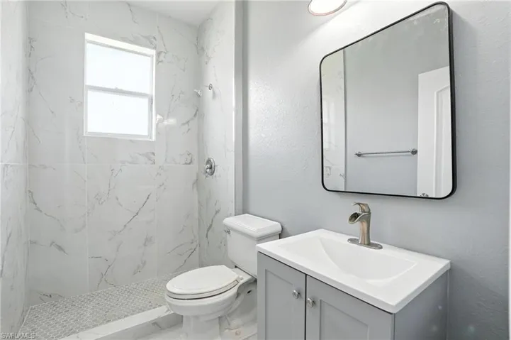 Full bathroom with vanity and a marble finish shower - Virtually Edited Image