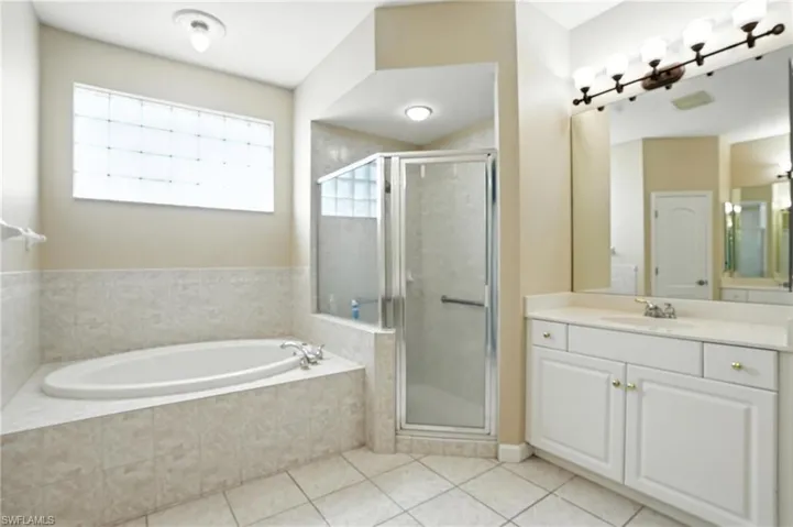 Full bath with vanity, a bath, tile patterned floors, and a stall shower - Virtually Edited Image
