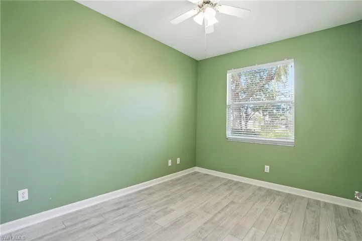 Unfurnished room with light wood-style floors and ceiling fan - Virtually Edited Image