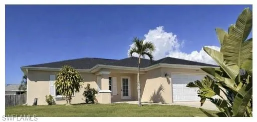 Ranch-style house featuring a garage, stucco siding, and a front yard