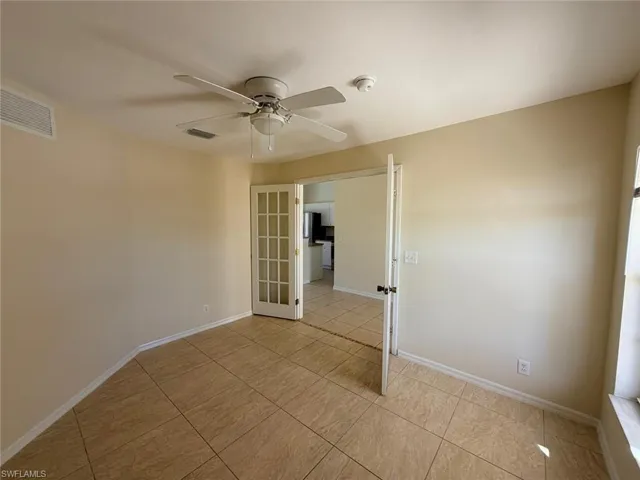 Unfurnished room featuring ceiling fan, french doors, and light tile patterned floors