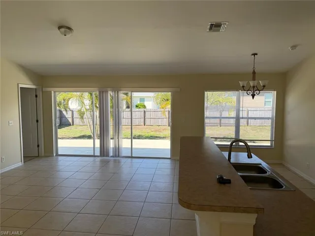 Kitchen with light tile patterned flooring, hanging lights, healthy amount of natural light, and light countertops