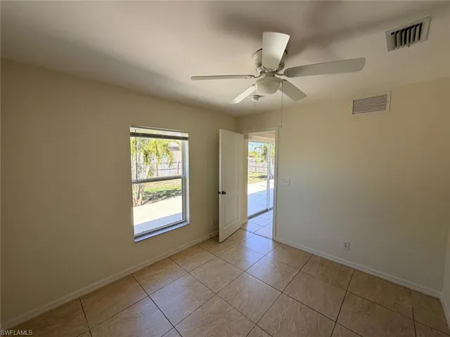 Unfurnished room with a ceiling fan and light tile patterned floors