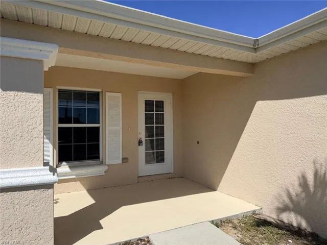 Entrance to property featuring stucco siding