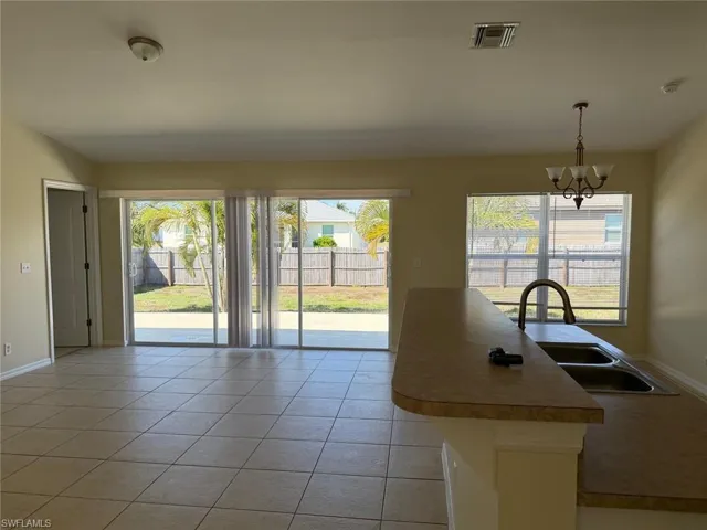 Kitchen featuring light tile patterned floors, light countertops, and a chandelier