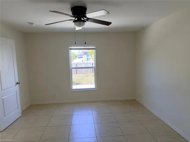 Unfurnished room featuring ceiling fan and light tile patterned floors