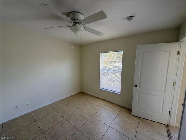 Spare room featuring a ceiling fan and light tile patterned floors