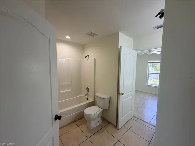 Full bath with bathing tub / shower combination, light tile patterned floors, recessed lighting, and ceiling fan