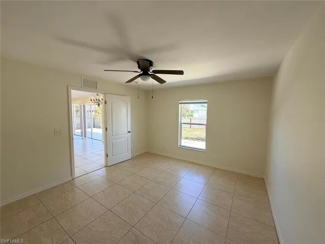 Unfurnished room with light tile patterned floors, a ceiling fan, and suspended lighting