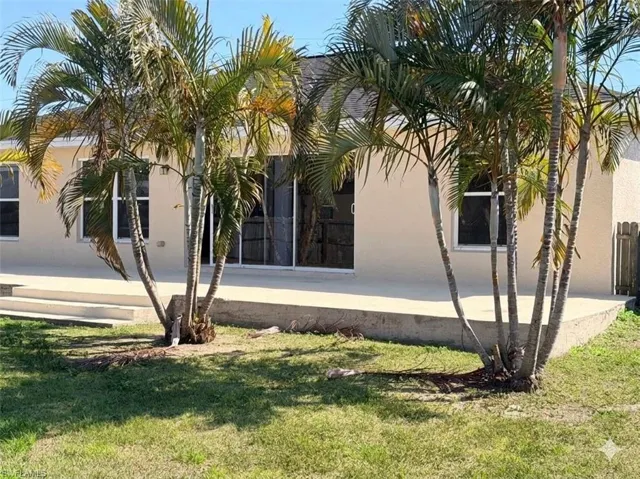 View of side of home with a yard and stucco siding