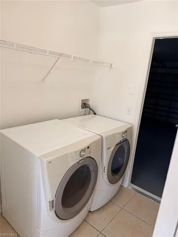 Laundry area with light tile patterned floors and washer and dryer