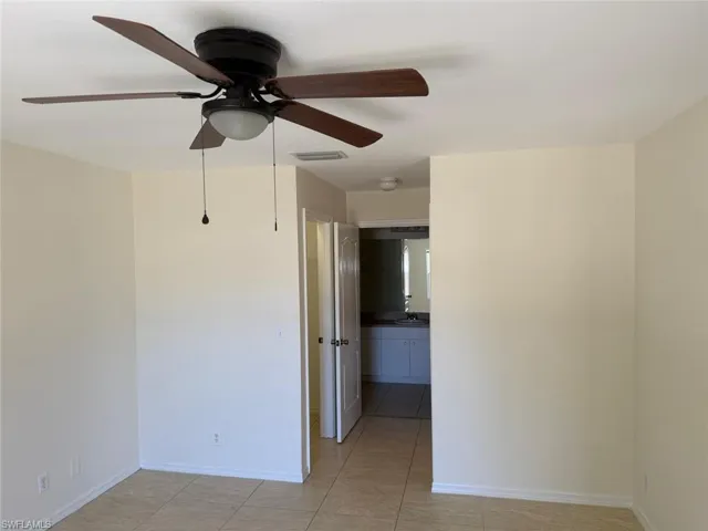 Empty room featuring ceiling fan and light tile patterned flooring