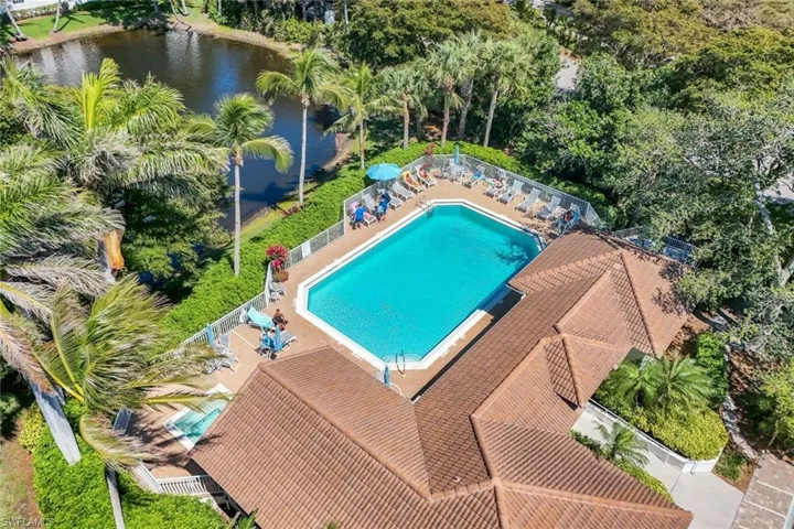 Community pool with a patio area, a water view, and fence