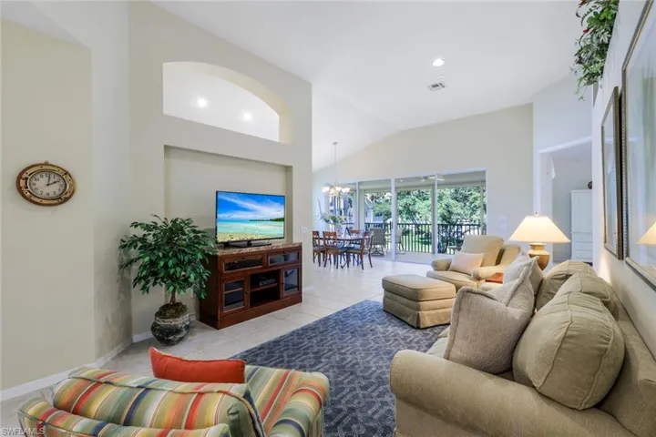 Living room with visible vents, a notable chandelier, recessed lighting, tile patterned flooring, and baseboards