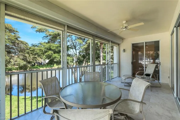 Sunroom with ceiling fan and a water view