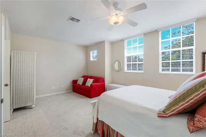 Bedroom with visible vents, baseboards, carpet, and a ceiling fan