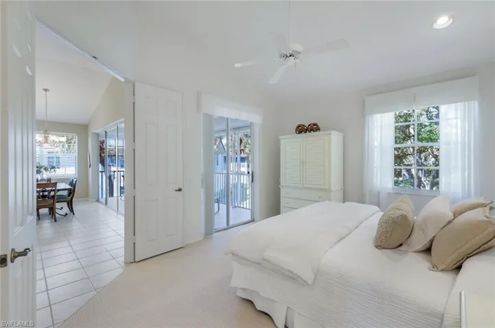 Bedroom featuring access to outside, light tile patterned flooring, light carpet, and vaulted ceiling