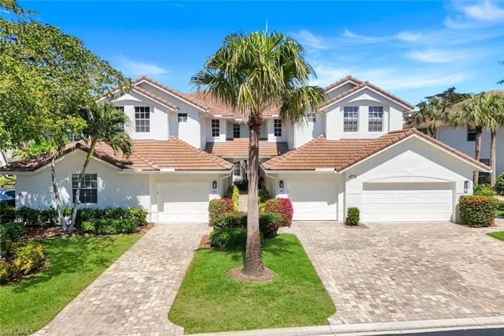 Decorative driveway, a front lawn, and a tile roof