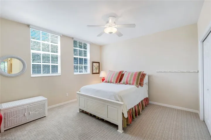 Bedroom with a ceiling fan, baseboards, and carpet floors