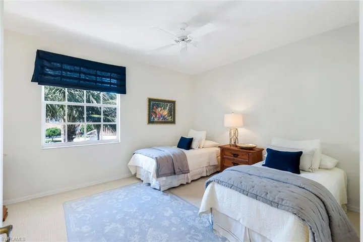 Carpeted bedroom featuring baseboards and a ceiling fan