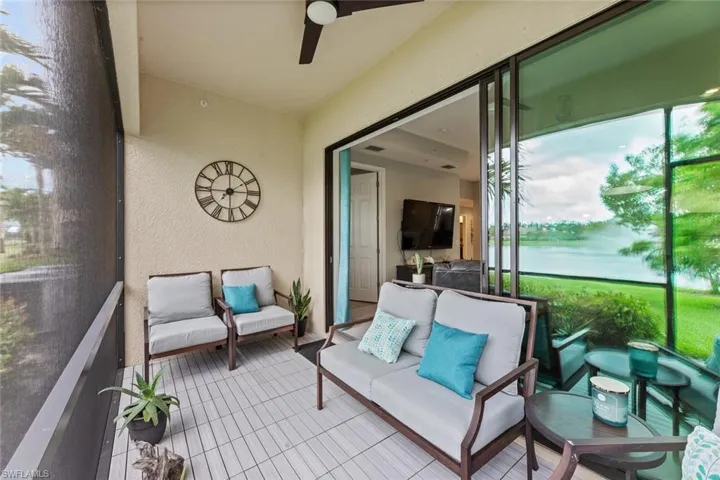 Sunroom with ceiling fan and a water view