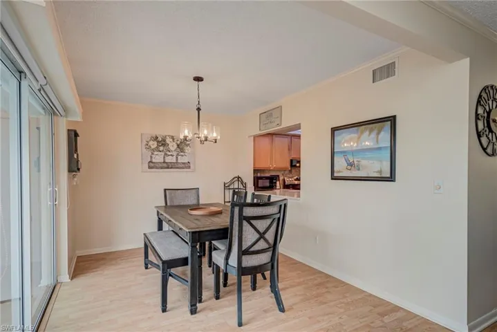 Dining area featuring crown molding, a chandelier, and light wood finished floors