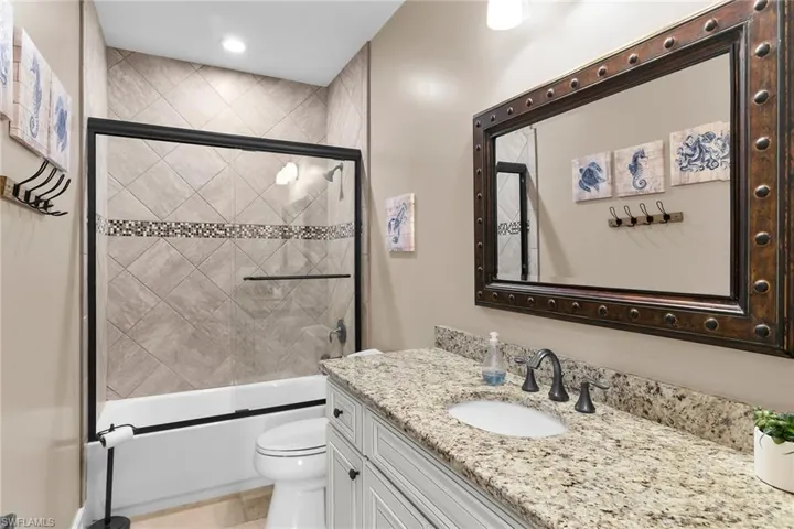 Full bath featuring vanity, combined bath / shower with glass door, and recessed lighting