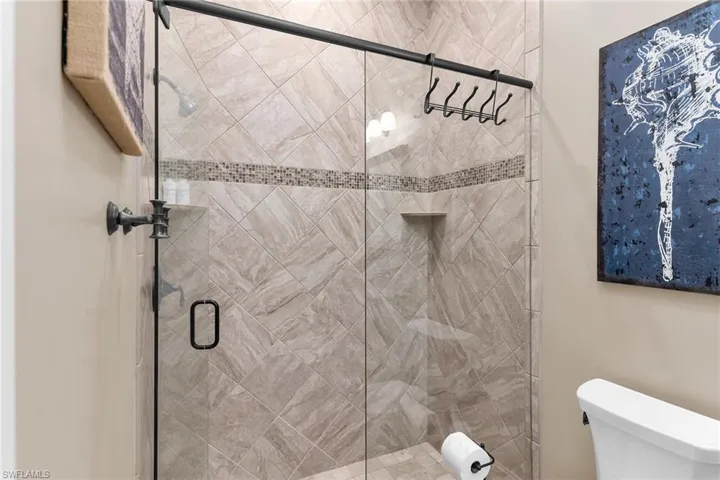 Full bathroom featuring a stall shower and toilet