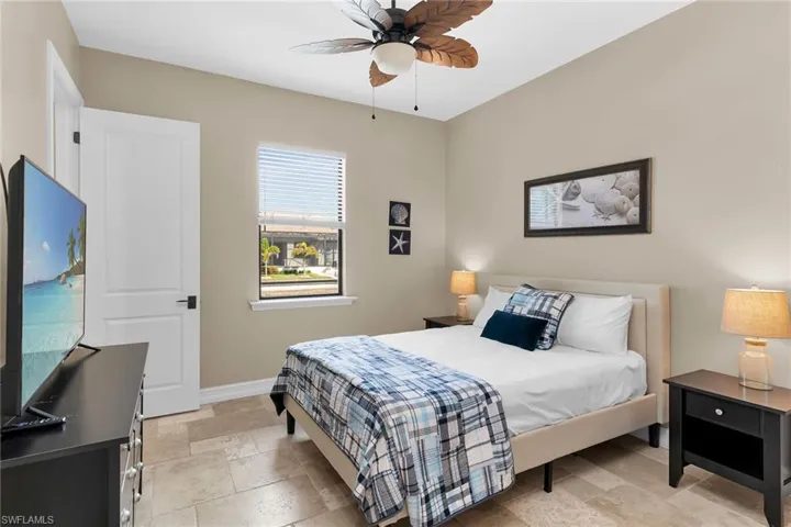 Bedroom with stone tile flooring and a ceiling fan