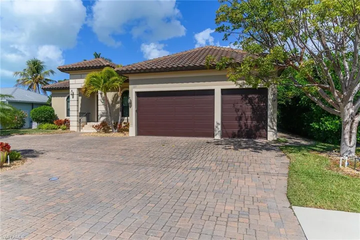 Mediterranean / spanish-style home with decorative driveway, stucco siding, a tile roof, and an attached garage