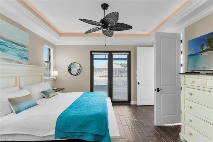 Bedroom featuring access to outside, ornamental molding, wood tiled floors, multiple windows, and a ceiling fan