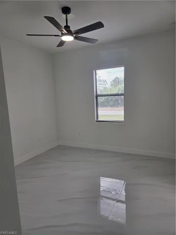Unfurnished room with baseboards and a ceiling fan