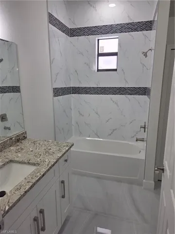 Full bath featuring washtub / shower combination and vanity