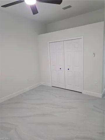 Unfurnished bedroom featuring a closet and a ceiling fan