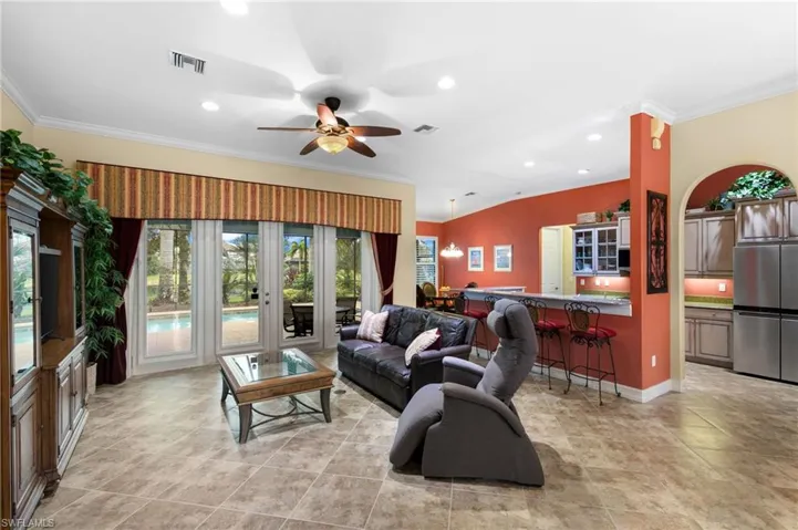 Living room featuring ornamental molding and ceiling fan