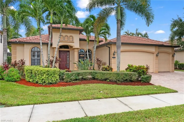 Mediterranean / spanish home featuring a garage and a front lawn