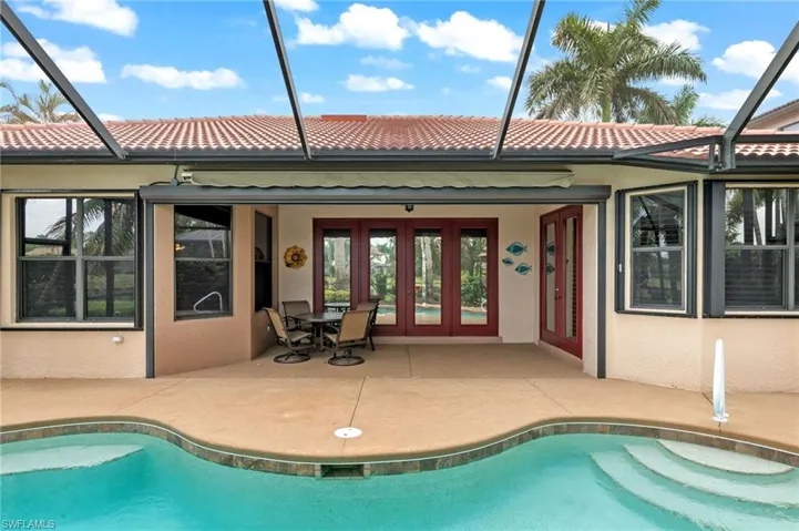 View of swimming pool with a lanai, a patio area, and french doors