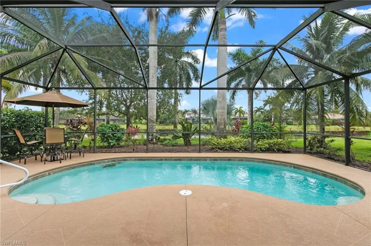 View of pool with a patio and glass enclosure
