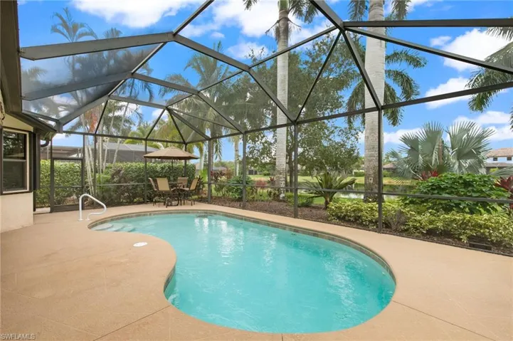 View of pool featuring glass enclosure and a patio area