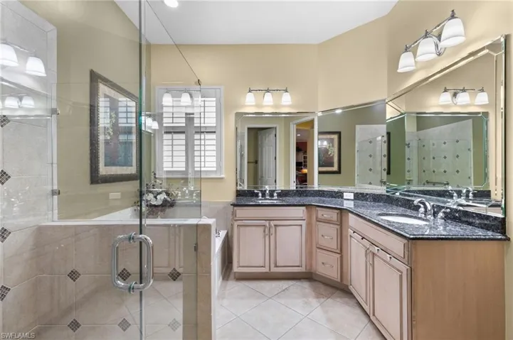 Bathroom with tile patterned flooring, independent shower and bath, and vanity