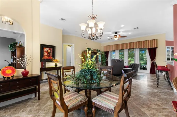 Dining room featuring ceiling fan with notable chandelier and ornamental molding