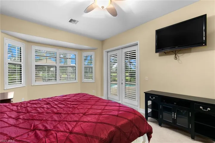 Carpeted bedroom featuring access to outside and ceiling fan