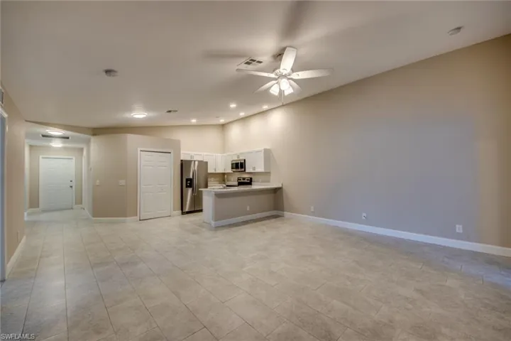 Unfurnished living room featuring ceiling fan and light tile patterned floors
