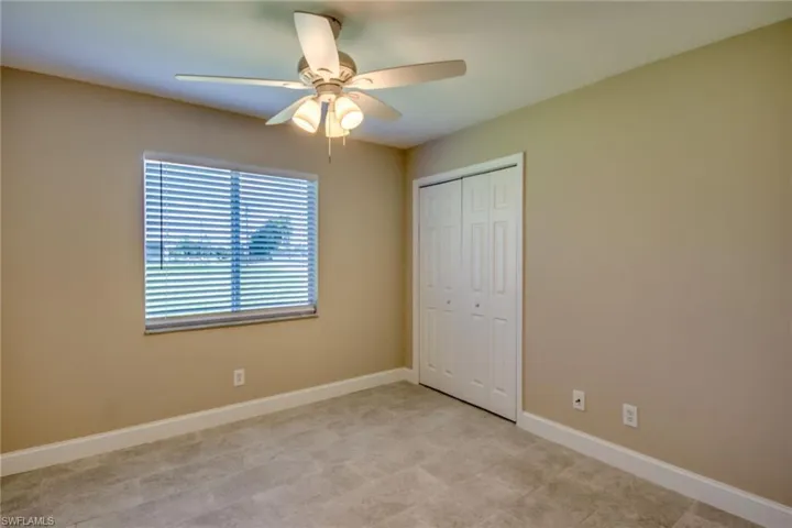 Unfurnished bedroom with ceiling fan and a closet