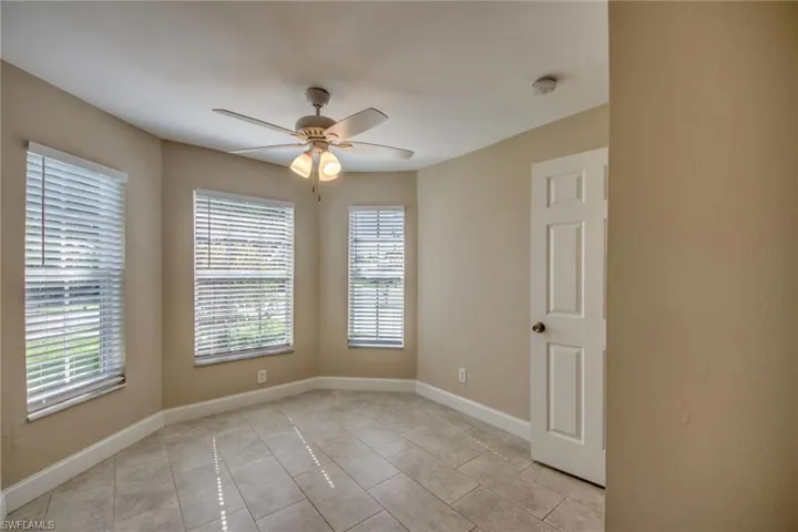 Empty room featuring ceiling fan and light tile patterned flooring