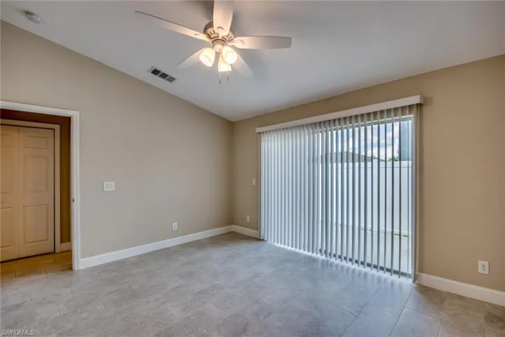 Spare room with light tile patterned floors, vaulted ceiling, and ceiling fan