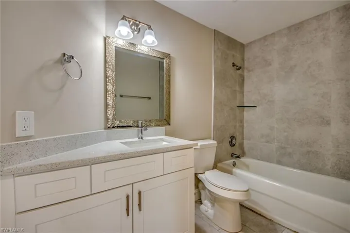 Full bathroom featuring tile patterned floors, vanity, tiled shower / bath, and toilet